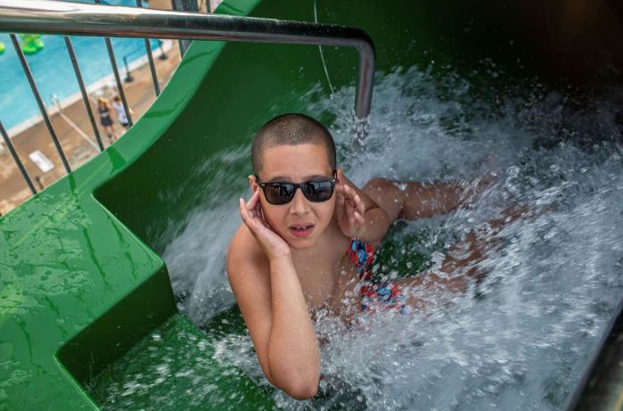 © Dayna Smith for the Washington Post/For the Washington Post Trevor Reed, 12, of Lanham, Md., holds his ears before going down a giant waterslide. 