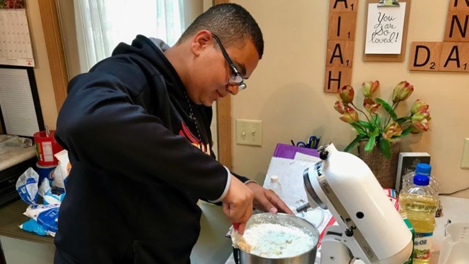 14-year-old Isaiah Tuckett mixes cupcake batter.