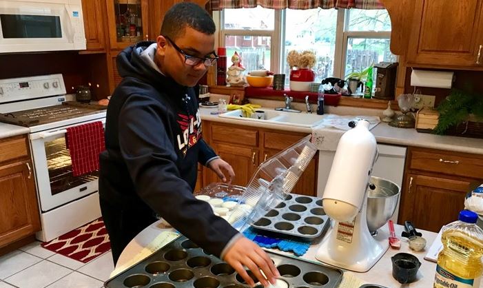 14-year-old Isaiah Tuckett makes cupcakes at his home in Madison, Minnesota. 