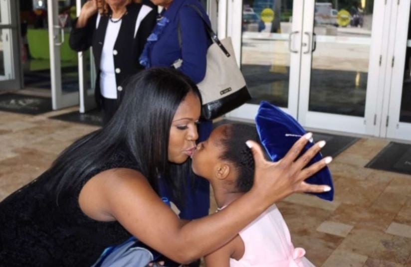 Yolanda Perkins kisses her daughter, Bella, 6, after Perkins' graduation ceremony on June 14. 