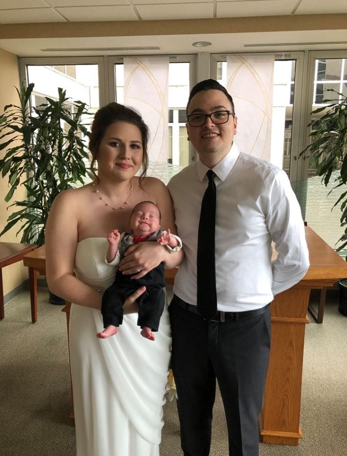 Amanda and Edwin Acevedo and baby Oliver wearing his little suit.