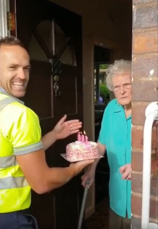 Garbage men surprise elderly woman on her 100th birthday with a cake and a little happiness. Credit: Ben Bird
