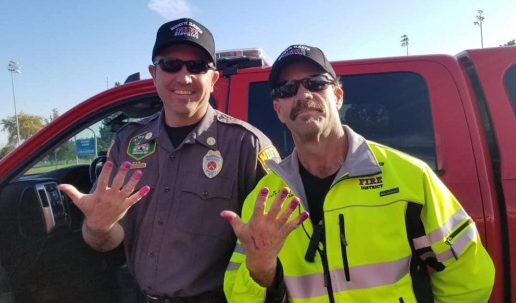 Firefighters calm scared little girl down after car crash by letting her paint their nails.