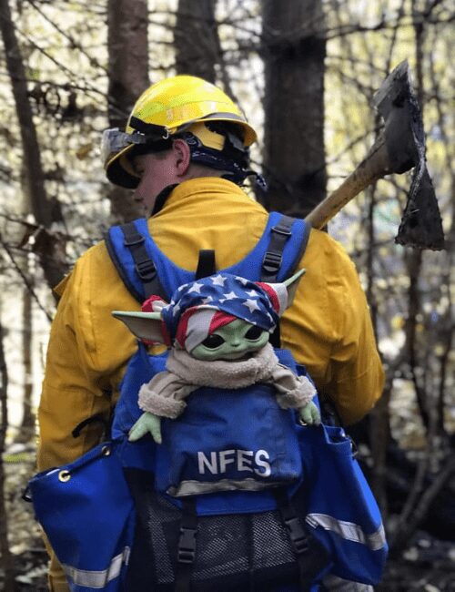 Oregon firefighter carries Baby Yoda on his back.