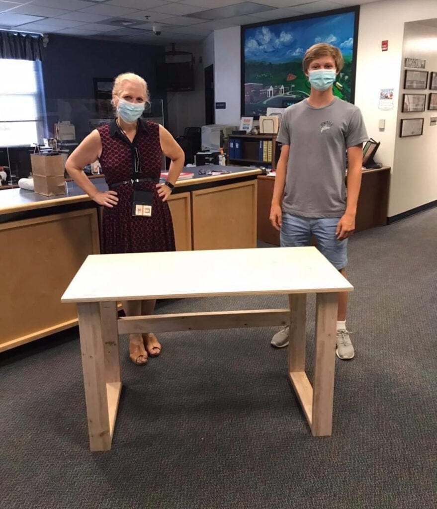 Teacher Kate Kurtzke and Colby Samide with her new desk he built.
