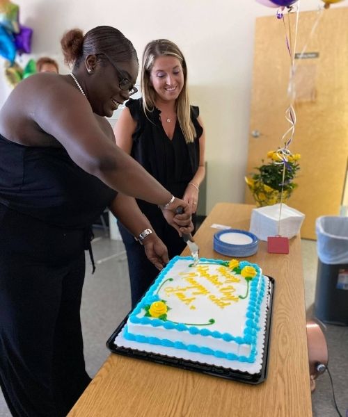 Monyay cutting a cake to celebrate being adopted by mom, Leah Paskalides.