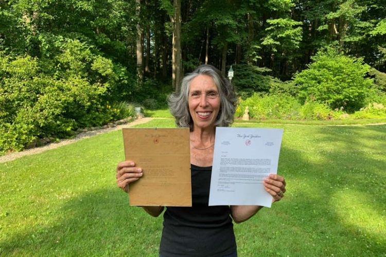 Gwen Goldman holding the two letters from former and current Yankees GMs.