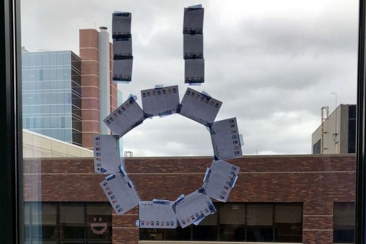 Boy undergoing cancer treatment makes new friends with hospital staff across the street using Post-it notes.