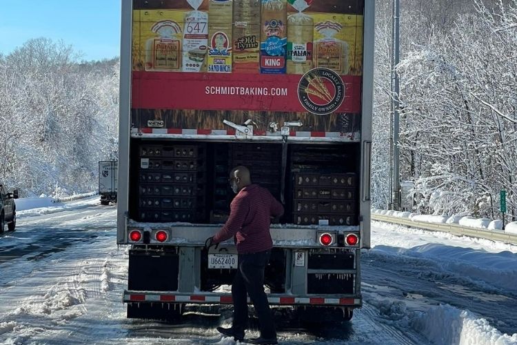 Bread truck driver, Ron Hill, opens truck to hand out food to hungry drivers.