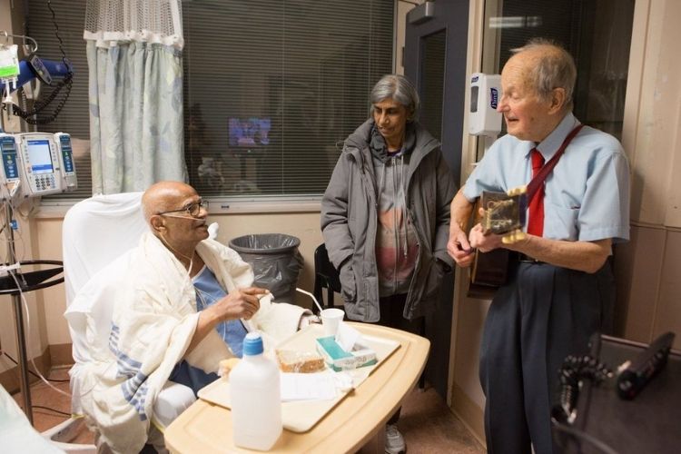 George Linton singing to hospital patient.