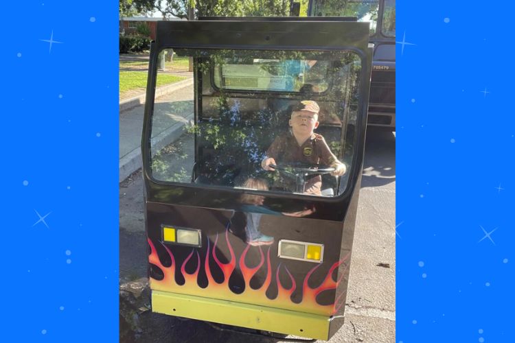 Drew in his new mini UPS truck complete with flames. (Becky Bausman).